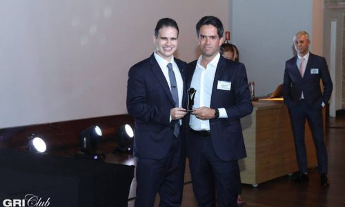 Imagem de dois homens segurando um troféu do GRI Awards 2023